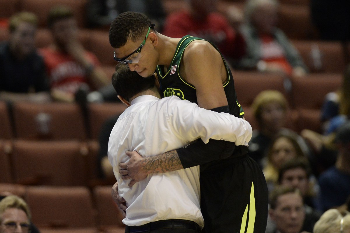 Исаии Остин обнимает своего тренера, после того, как его сняли с матча по состоянию здоровья